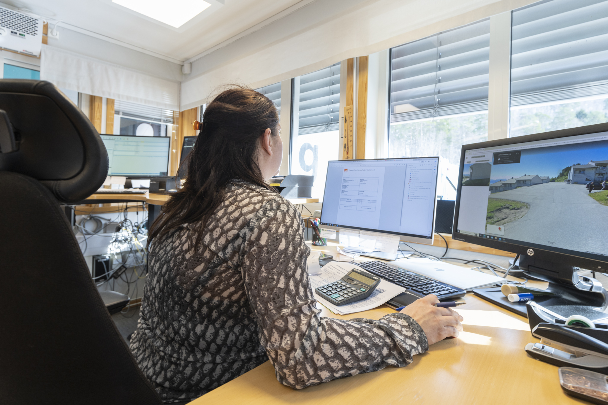 Ansatt som ser på skjermer, med flere skjermer i bakgrunnen