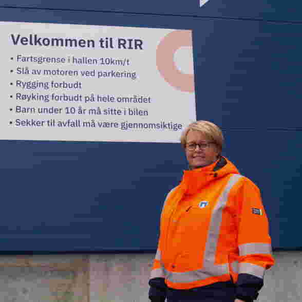 Avdelingsleder Vibeke Sommernes foran velkomstskilt for ny gjenvinningsstasjon
