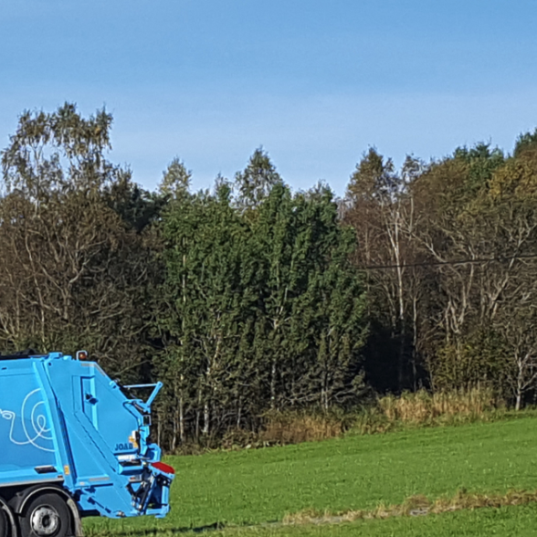 To renovasjonsbilder fra RIR i et område med grønt gress og skog