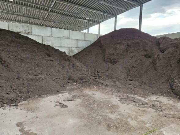 To hauger med ferdig kompost ligger under et tak