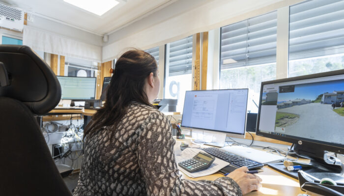 Ansatt som ser på skjermer, med flere skjermer i bakgrunnen